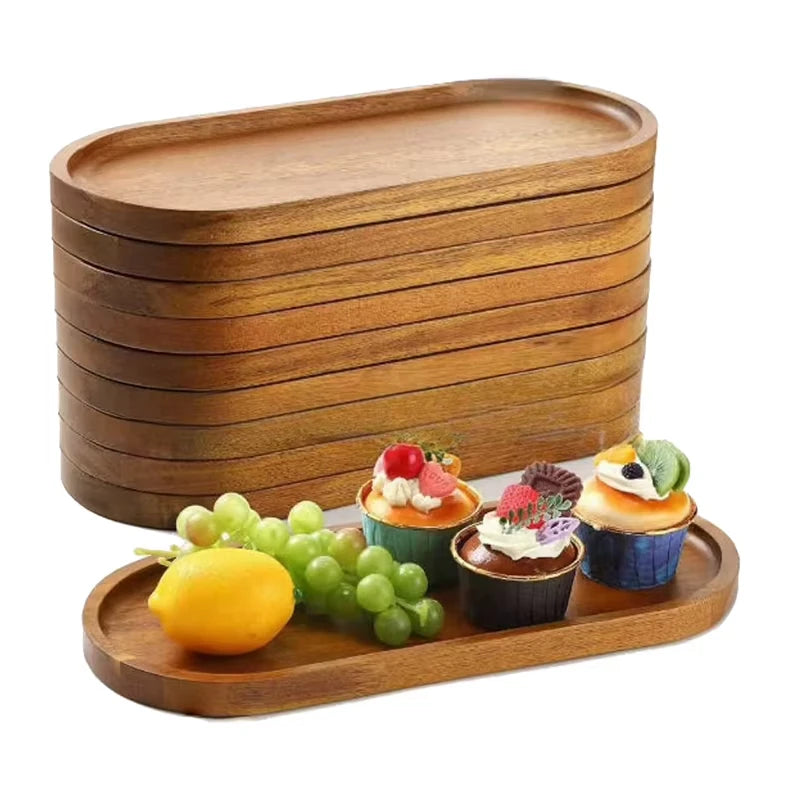 A stack of Ridgeline wood trays beside one tray styled with lemon, grapes, and cupcakes